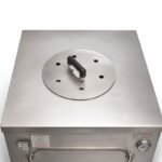 Stainless Steel Tandoor Oven Lid AS11 – overhead angled view of the round stainless steel lid placed on top of a Morni commercial tandoor oven, showing the black heat-resistant handle, six ventilation holes, and brushed stainless steel surface resting on the square oven top, with Morni branding and thermometer visible on the front panel