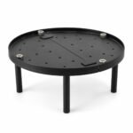 Tandoor Baffle Plate AS02 – fully assembled round black steel baffle plate on four legs, showing perforated surface with air-flow holes, centre divider bar, and four stainless steel hex bolt leg fasteners, angled three-quarter view on white background