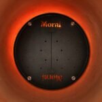 Tandoor Baffle Plate AS02 – top-down view of baffle plate installed inside a lit tandoor oven at operating temperature, showing glowing orange clay walls, the Morni-branded black steel plate with perforated holes and centre divider, and orange heat glow visible through the ventilation holes