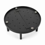 Tandoor Baffle Plate AS02 – overhead angled view of fully assembled standalone baffle plate showing round black steel perforated disc with evenly distributed air-flow holes, diagonal centre divider bar, four stainless steel hex bolt leg mounts, and four supporting legs on white background