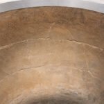 Tandoor Clay Pot Repair Kit AS08 – close-up overhead view of the cracked inner clay wall of a tandoor oven showing an extensive network of fractures and surface fissures across the terracotta clay pot interior, with the stainless steel jacket rim visible at the top, showing the type of damage the repair kit is used to restore
