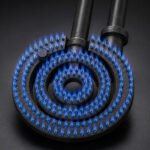 Tandoor Oven Burner AS06 – nozzle-tip tandoor burner ignited inside a tandoor oven showing intense blue and orange gas flames rising from the stainless steel nozzle tips, captured at initial ignition with high flame output