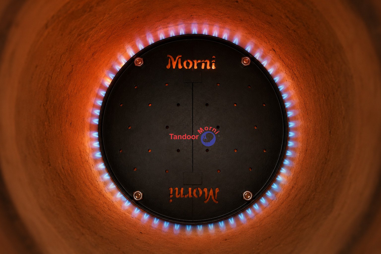 High temperature tandoor use: a properly moderated blue-orange flame with the vents open during a controlled high-heat cook