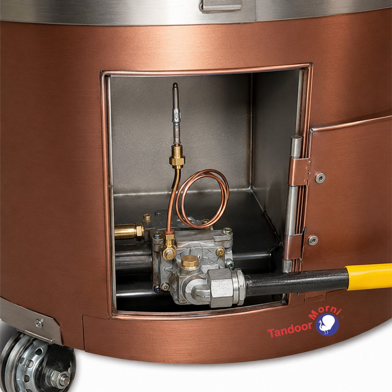 Close-up of a tandoor oven thermocouple and gas valve assembly inside a polished copper tandoor oven